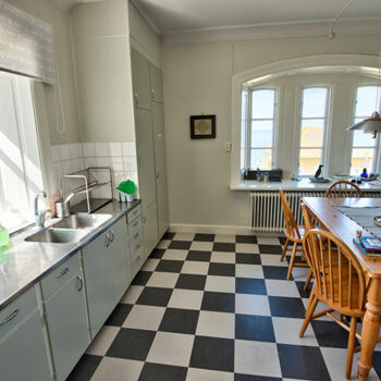 Kök med härligt ljusinläpp och rutigt golv, foto.
