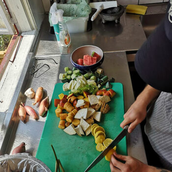En kock skär upp grönsaker i köket.
